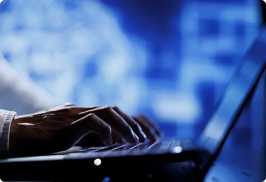 Kéz laptop billentyűzetén, digitális háttérrel