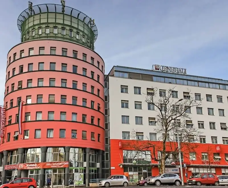 A Generali székház vörös, hengeres irodatornya és a mellette álló irodaszárny, utcaszinti üzletekkel